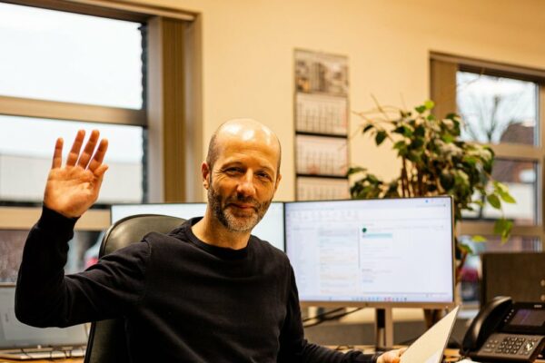 Administratief medewerker aan het bureau met technische plannen en telefoon